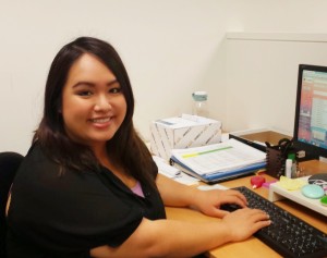 Anh Van, Development Associate, sitting at her desk with computer in front of her.