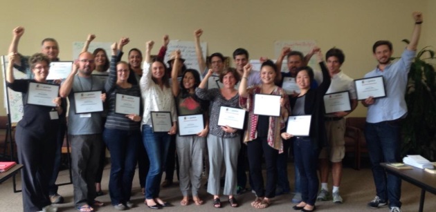 Exec Fellows Graduation Picture raising their hands and holding their certificates