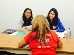 [Photo: Lowenstein Sandler LLP attorney volunteers assist a client with citizenship matters at the July 2014 clinic.]
